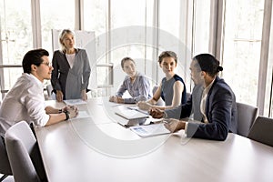 Marketing department discuss project gathered together in conference room