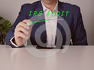 Marketing expert writing IRS AUDIT Internal Revenue Service on a transparent virtual interface with a marker pen photo