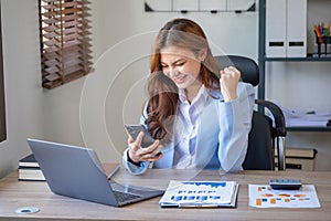 Marketing, Finance, Accounting, and Planning. An Asian businesswoman uses a mobile phone to contact a customer to inform her of