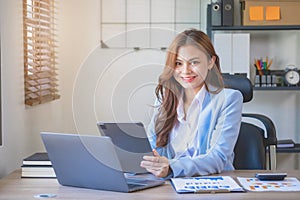 Marketing, finance, accounting, planning, female accountant portrait with beautiful smile wearing team blue suit using laptop