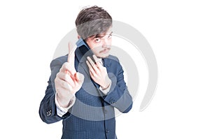 Marketing manager talking at phone showing wait a second gesture