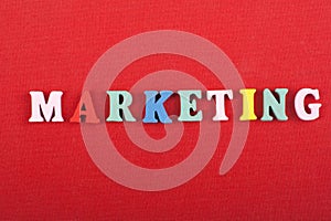 MARKETING word on red background composed from colorful abc alphabet block wooden letters, copy space for ad text. Learning