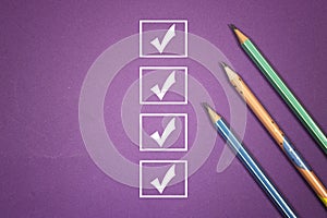 Marking on checklist box. Checklist concept, three pencils with copy space on purple background