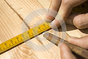 Marking distances. The carpenter`s hands measure distance measure.