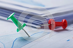 Marking financial chart by pins.Share listing and checking financial chart. Concept of banking, financial report and financial