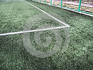 The marking of the football field on the green grass. White lines no more than 12 cm or 5 inches wide. Football field area