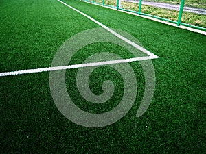 The marking of the football field on the green grass. White lines no more than 12 cm or 5 inches wide. Football field area