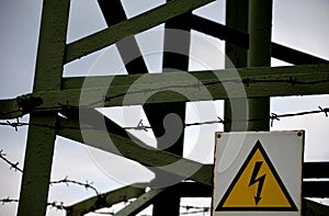 Marking of a high-voltage metal pole with a yellow triangle and the shape of a lightning bolt. protection against entry of unautho