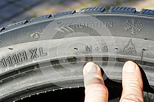Markings on the sidewall of a new winter tire, speed, load, rotation, mud and snow designations photo