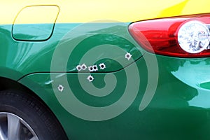 The marks bullets hole on the car bonnet, shrapnel bullet shot cracked hole on car surface, shoot the car photo