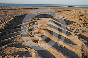 The marks of the wheel of the tractor that cleans the beach is Barcelona