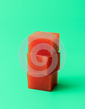 Marmalade cubes isolated on a green background. Homemade quince marmelade