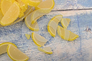 Marmalade lemon slices on wooden background. Sweet dessert. Close up