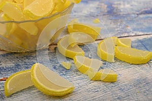 Marmalade lemon slices on wooden background. Sweet dessert. Close up