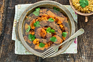 Maroccan lamb tajine with couscous garnished with fresh coriander leaves