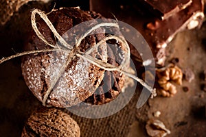 Maroni cookies with pieces of chocolate and walnuts on old wooden background