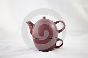 Maroon ceramic teapot on white background