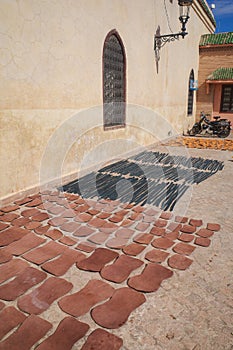 Marrakech, Morocco - Feb 10, 2023: Tanned leather pieces drying in the sun on a street in the Medina of Marrakech