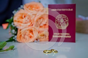 Marriage Certificate of the Republic of Azerbaijan .Yellow gold engagement rings against the background of a bouquet of
