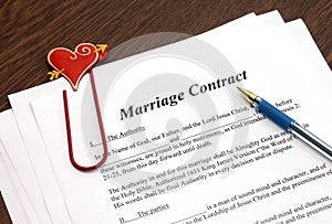 Marriage contract with pen on wooden table
