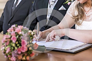 Marriage elegant bride signing register, holding pen and official document wedding couple