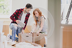 Marriage packing stuff into carton boxes while moving-out to new house