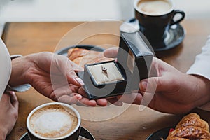 marriage proposal, hands holding engagement ring in a box