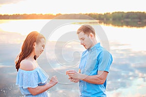 Marriage proposal on sunset . young man makes a proposal of betrothal to his girlfriend on the beach