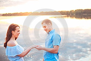 Marriage proposal on sunset . young man makes a proposal of betrothal to his girlfriend on the beach