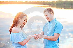 Marriage proposal on sunset . young man makes a proposal of betrothal to his girlfriend on the beach