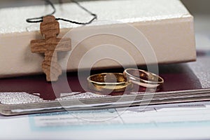 Marriage rings close to bible with wooden cross.