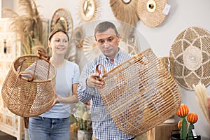 Married couple chooses a wicker laundry basket in furniture store