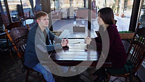 Married couple discussing relocation in coffee house.