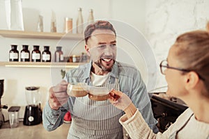 Married couple drinking coffee together in the kitchen.