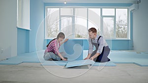 married couple is engaged in home improvement and renovation and insulates floor with expanded polystyrene