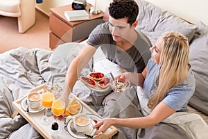 Married couple enjoying breakfast in bed