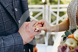 Married couple exchange wedding rings at Indonesian wedding ceremony. Groom put a ring on finger of his lovely wife. The