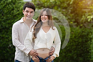 Married couple is expecting baby. man embraces his pregnant wife