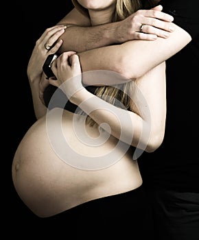 Married couple expecting a baby: young man, new daddy hugging his pregnant wife.