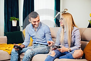 married couple having fun with modern technology console online, playing videogames and enjoying the weekend photo