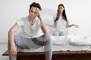 Married Couple Having Quarrel, Sitting In Bedroom At Home