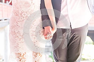 Married couple holding hands, wedding day ceremony