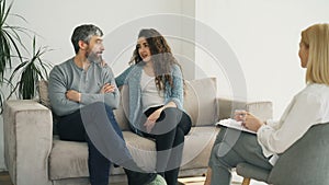 Married couple listening professional psychologist and trying to solve relationship porblems during visit