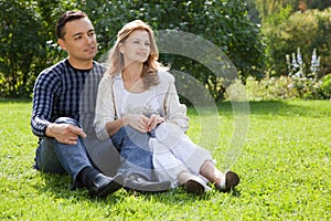 Married couple looking aside outdoors photo