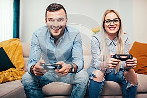 Married couple playing video games on general gaming console. Details of modern lifestyle with couple having fun