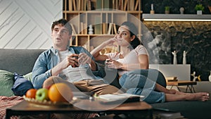 Married couple relaxing couch with coffee cozy weekend evening. Spouses talking