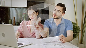 A married couple are working together at home