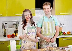 Married smiling couple cooking apple pie at the kitchen at home