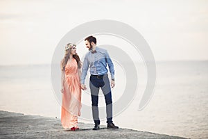 Married wedding couple standing on a wharf over the sea