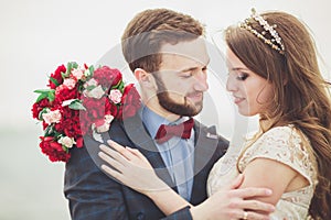 Married wedding couple standing on a wharf over the sea